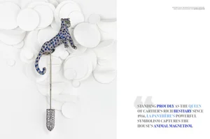Cartier diamond and sapphire panther cliquet pin set against sculpted white paper circles on an editorial magazine layout.