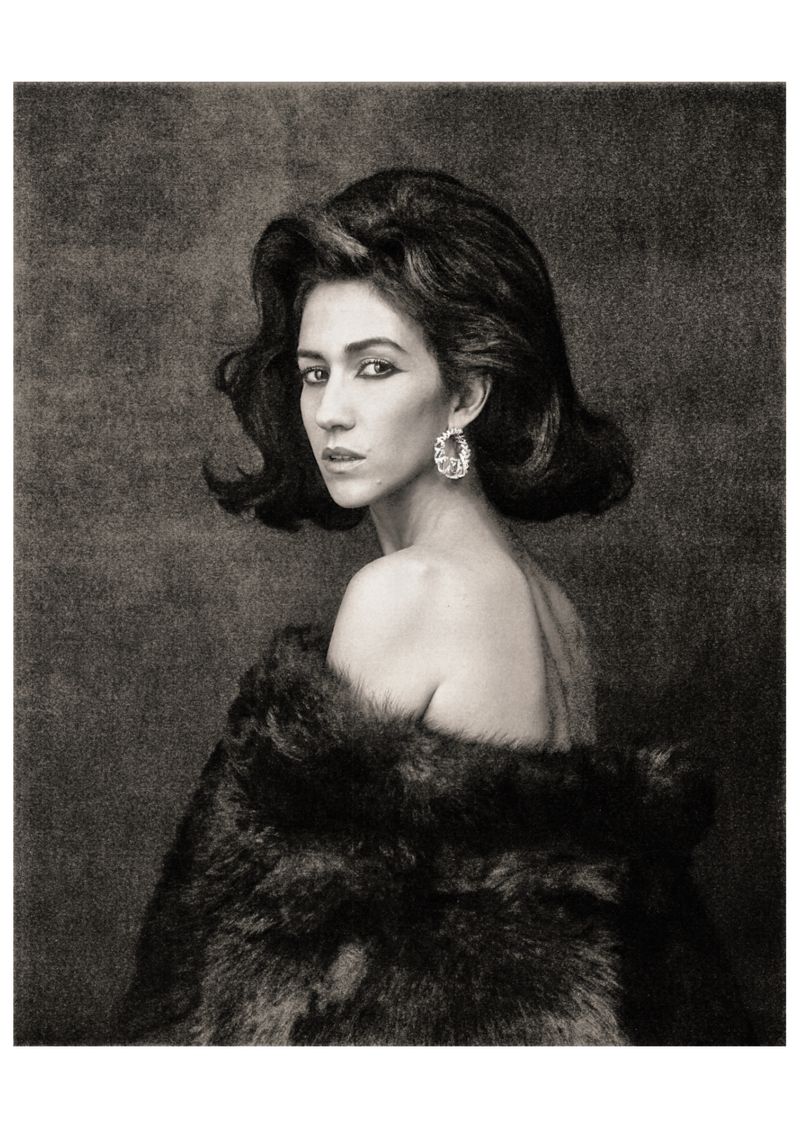 Black and white portrait of Delfina Delettrez looking over her shoulder wearing a dark fur wrap and statement earring.