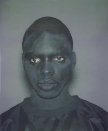 Portrait of a Black man with dark body paint wearing a dark t-shirt against a neutral grey seamless background for Yeezy YZY SZN X.