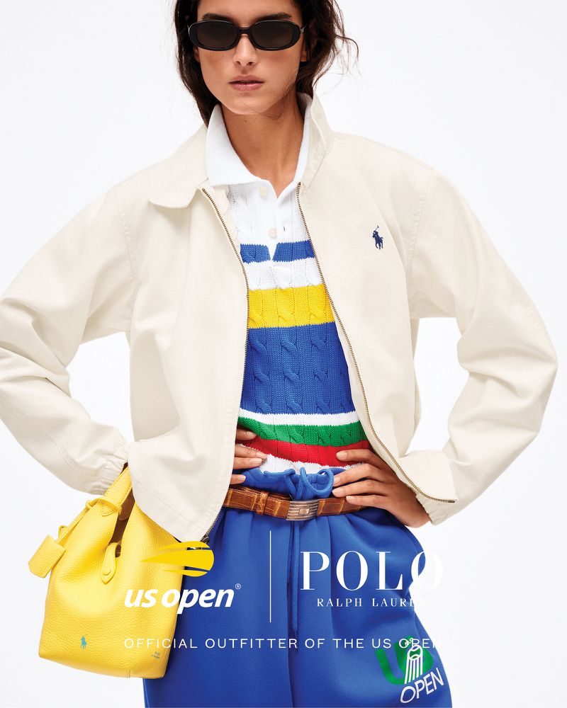 Fashionable woman in cream jacket and blue pants poses with a yellow handbag for a Polo Ralph Lauren US Open apparel ad.
