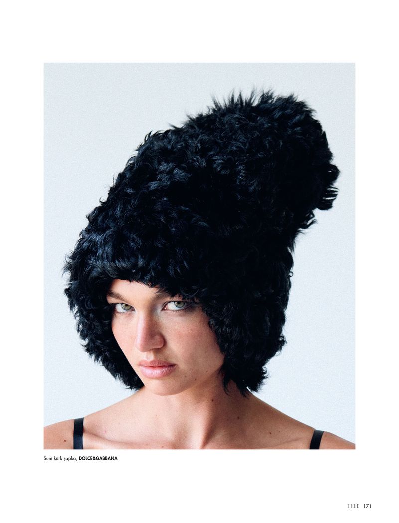 Fashion portrait of woman wearing a black fur hat against white background. Beauty shot with clean studio lighting and natural makeup.