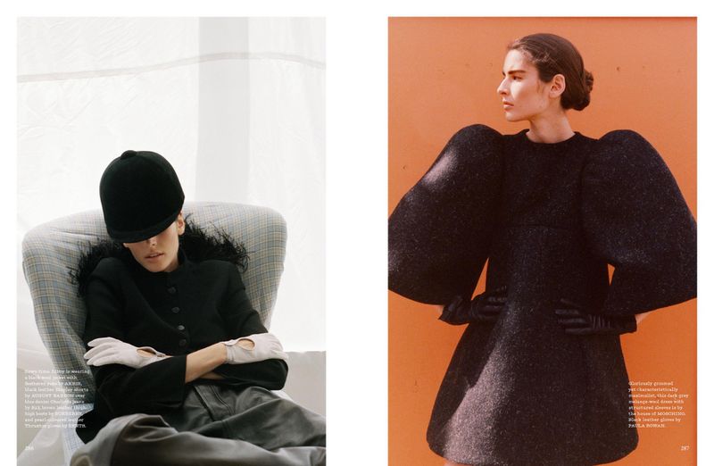 Editorial fashion shot featuring two women. One woman in a black riding helmet and blazer sits in a chair while the other wears a dress.