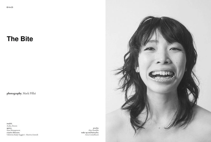 Black and white portrait of a smiling adult woman with dark hair and shiny grills over her teeth in a studio with text to the side.
