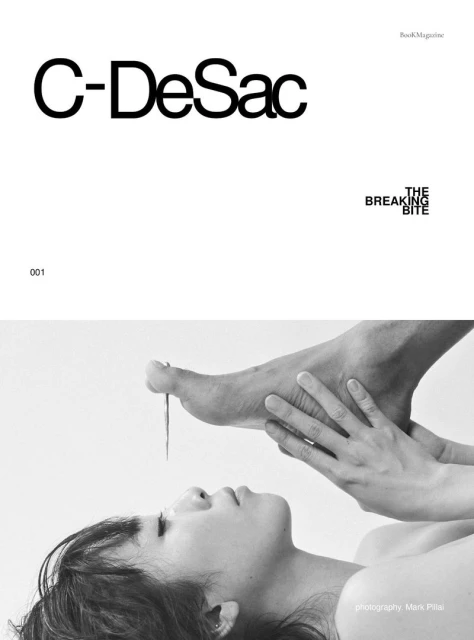 Magazine cover with a woman lying down as someone holds a foot above her face with a needle piercing the big toe in a studio.