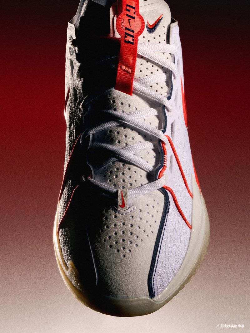 Close-up shot of a white and red Nike GT Cut 3 basketball shoe, showcasing its design and features with a blurred red background.