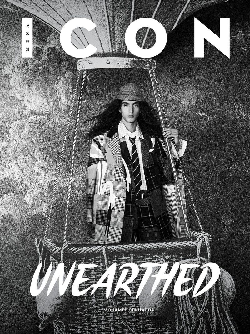 Magazine cover featuring a stylishly dressed male model in a hot air balloon basket, against a backdrop of clouds and vintage aesthetics.