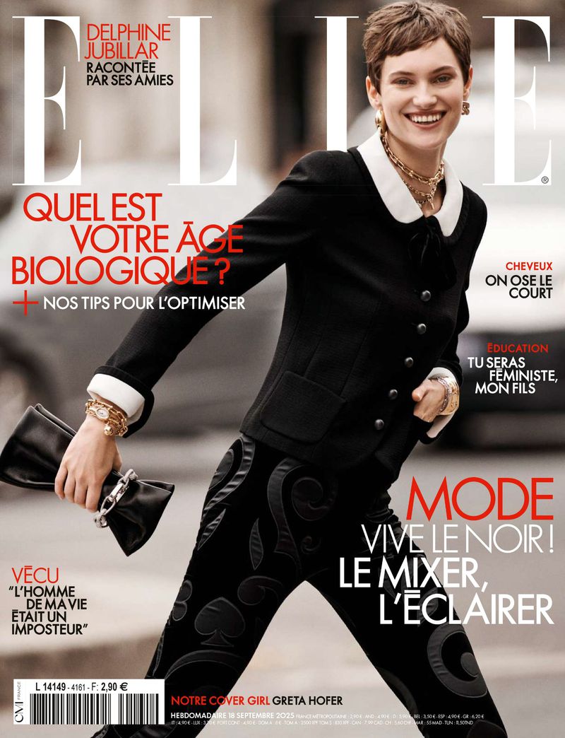 Elle magazine cover featuring a smiling woman with short hair wearing a black jacket, patterned pants, and gold jewelry in an outdoor setting.