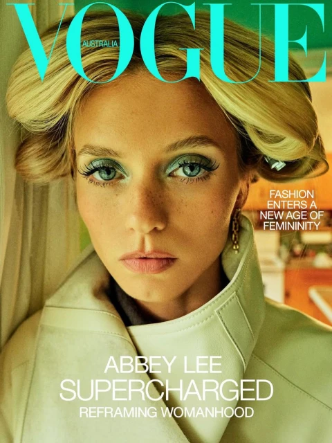 Magazine cover featuring a close-up portrait of Abbey Lee with blonde hair, light makeup, and a light-green trench coat. Vogue Australia.