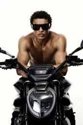 Shirtless male model wearing black sunglasses leaning over a dark motorcycle against a white background