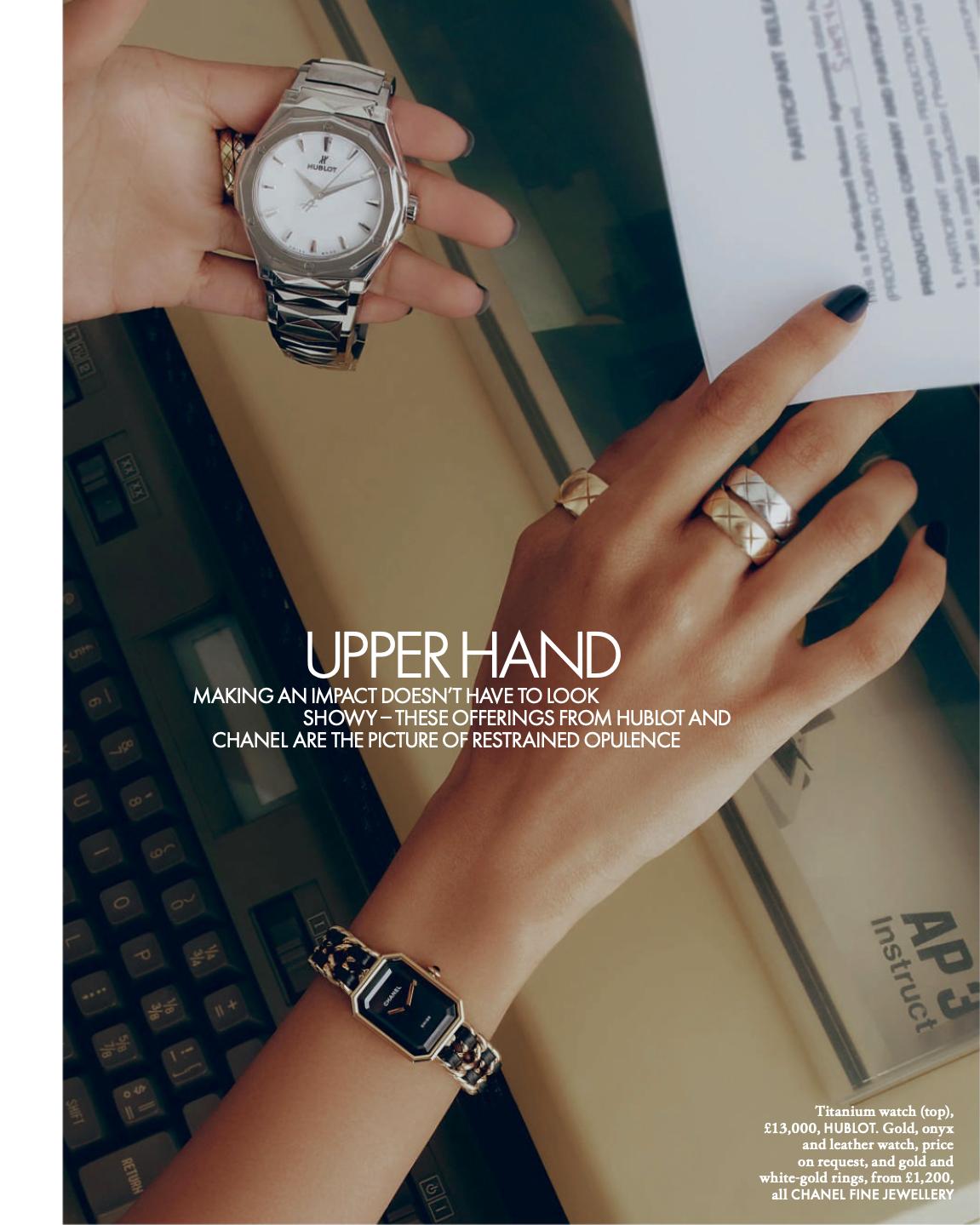 Close-up of a person's hands showcasing luxury watches and rings, featuring metallic and gold jewelry against a neutral background.