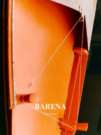 Close-up view of an orange gondola showing construction and design details, with a white rope and the logo of Barean Venezia.