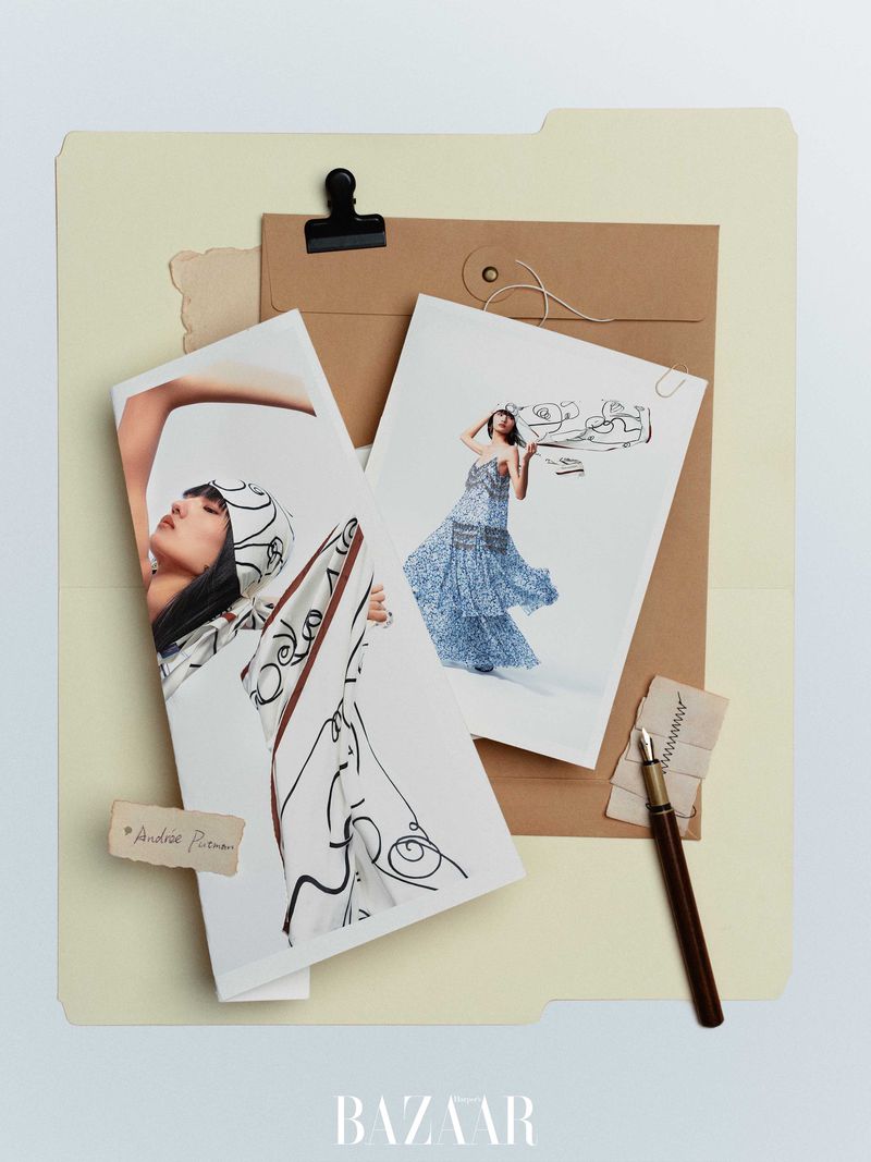 Fashion-themed flat lay featuring model photos, fountain pen, and document folder on a neutral surface, creating a stylish, editorial composition.