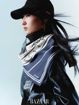 Model wearing a black cap, black leather jacket, and patterned scarf against a light background for Harper's Bazaar China