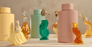 Frank Green reusable water bottles in pastel pink, mint, and yellow styled with vintage glass and ceramic figurines on a tabletop.
