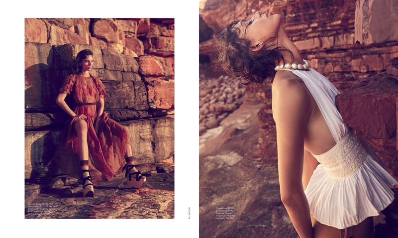 Two women posing in gowns against a rocky, natural backdrop. Editorial fashion shot with textured rock formations and soft lighting.
