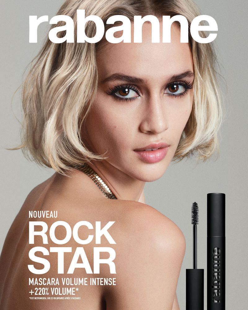 Glamorous beauty shot features a woman with blonde hair and a gold chain, showcasing Rabanne mascara with a full tube and applicator.
