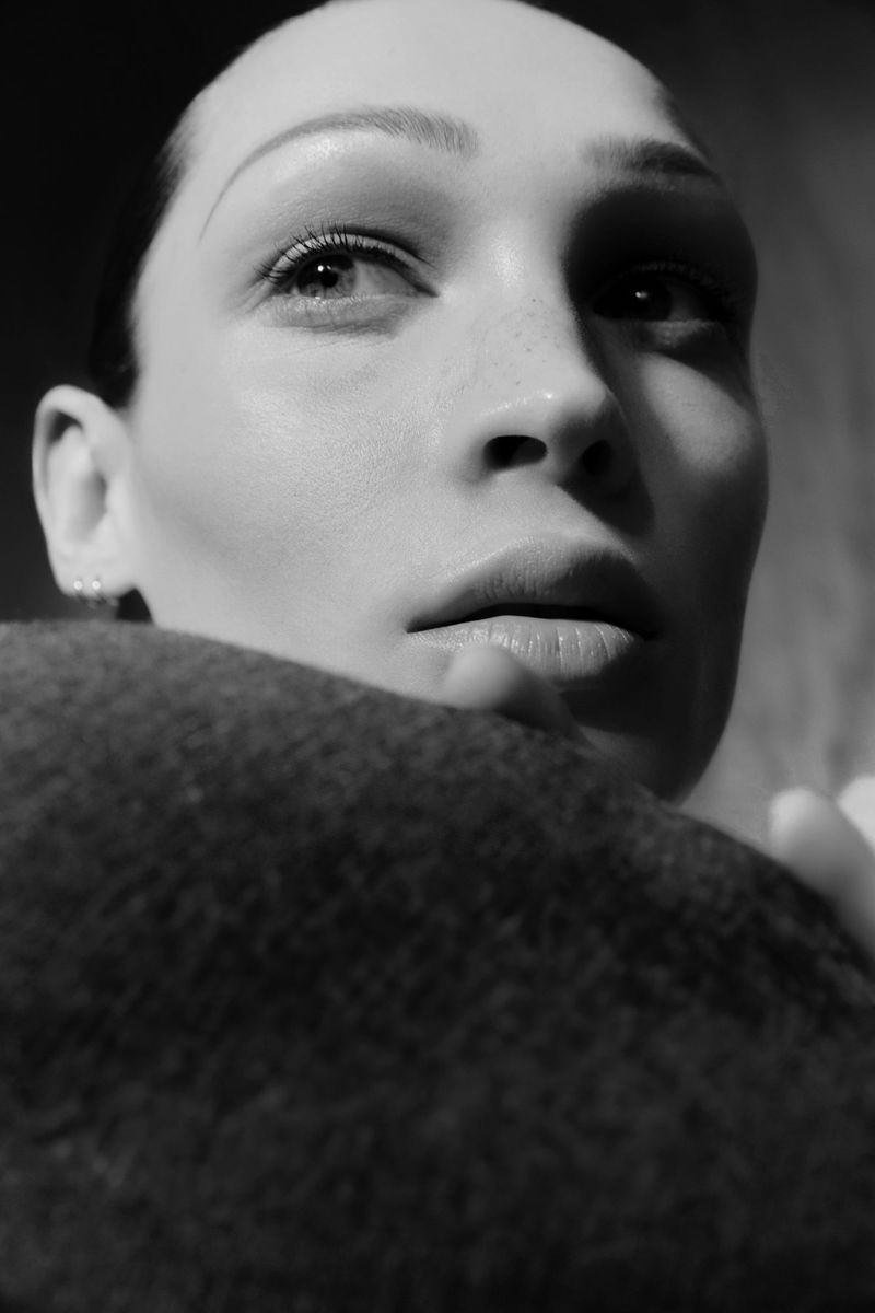 Black and white close-up portrait of model Dalton Dubois leaning against a dark textured wool fabric.