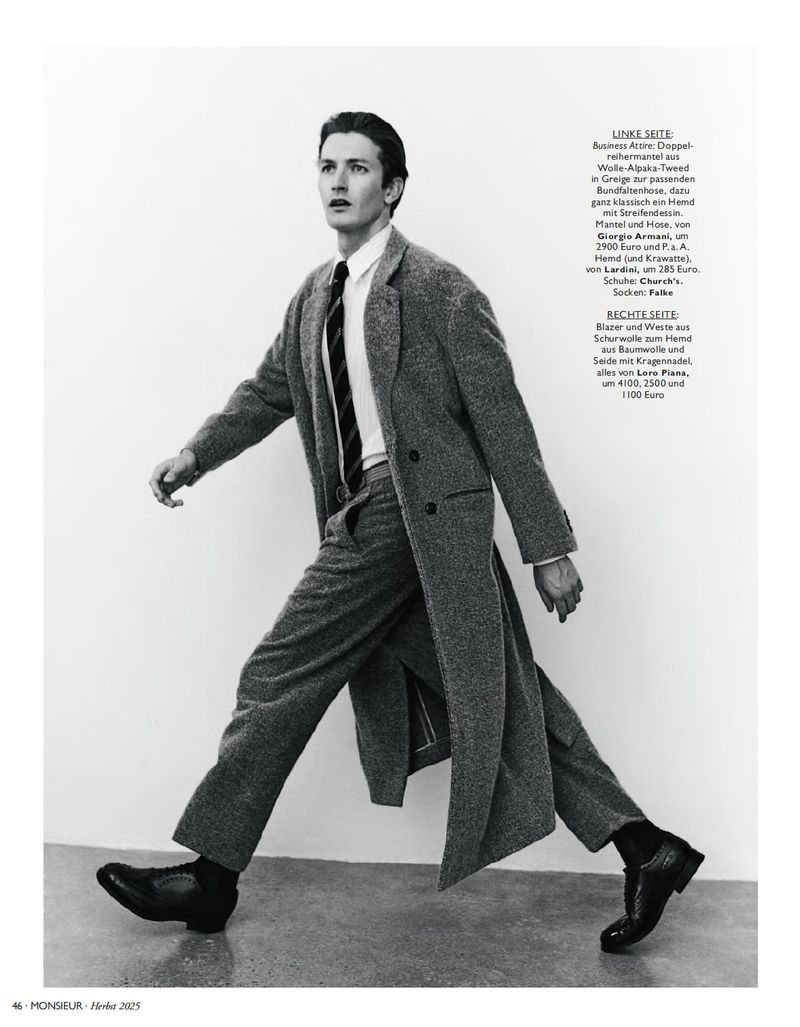 Black and white editorial photo of model Oli Lacey walking in a grey tweed overcoat, tailored trousers, and black dress shoes.