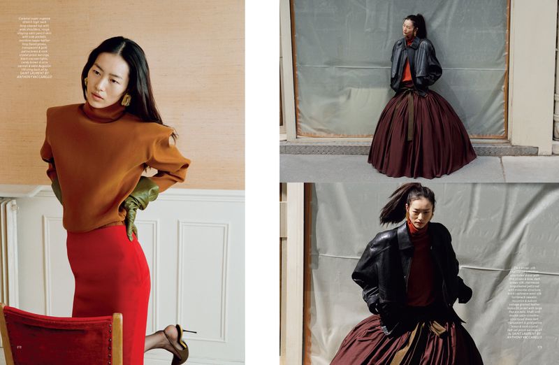 Editorial fashion shot of a slender Asian woman in a rust-colored turtleneck and long red skirt, posing with chair and architectural details.