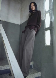 Model Yilan Hua posing on a staircase for Mango Strictwear Burgundy editorial