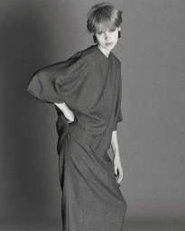 Model wearing a dark long-sleeved dress against a seamless grey backdrop for D Repubblica