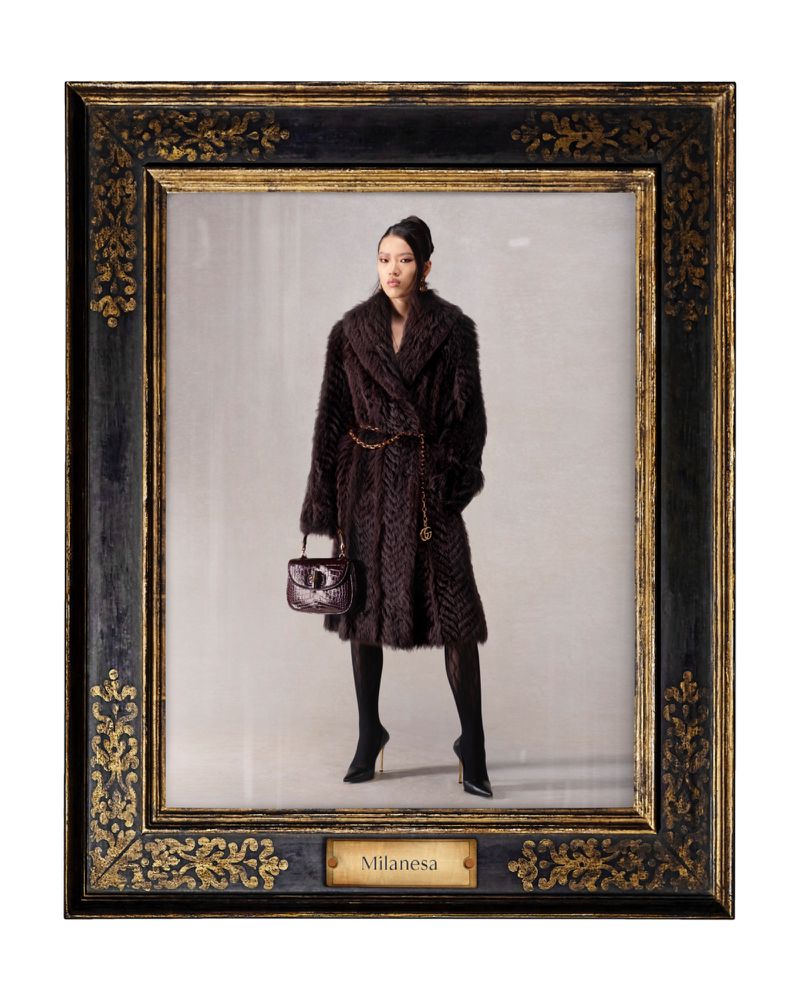 Framed portrait of a woman wearing a fur coat, tights, and heels, holding a purse, against a neutral studio backdrop, with gold detailing.