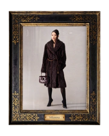 Framed portrait of a woman wearing a fur coat, tights, and heels, holding a purse, against a neutral studio backdrop, with gold detailing.