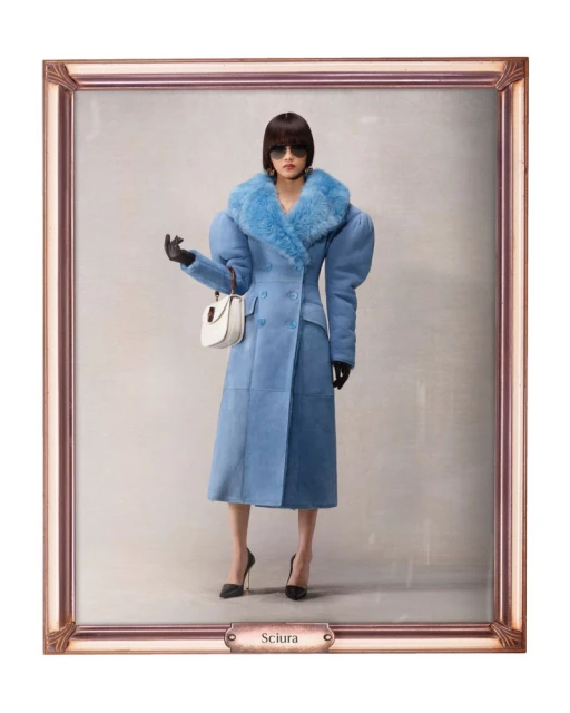 A stylish woman in a light blue shearling coat, black heels, and sunglasses, stands against a neutral backdrop in an ornate frame.