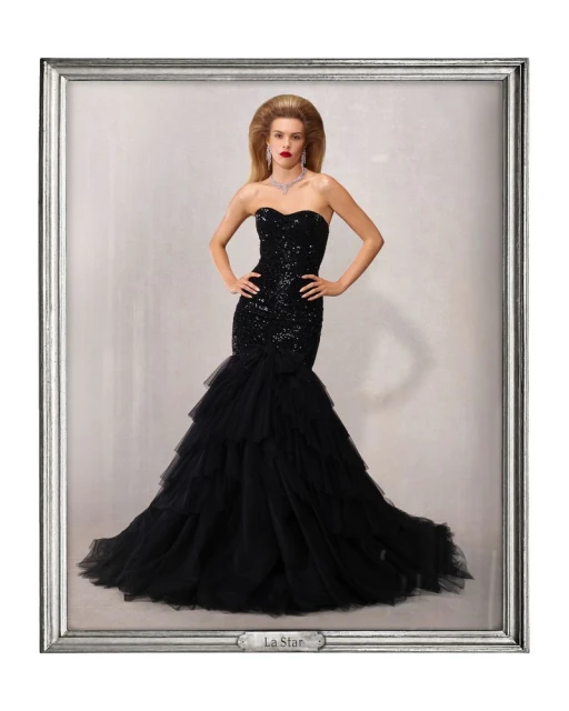 Glamorous woman in sequined black gown with a layered skirt, posing in front of a textured backdrop, framed in silver.