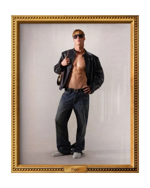 Muscular man in jeans and a leather jacket strikes a confident pose in a studio portrait against a neutral backdrop, framed in gold.