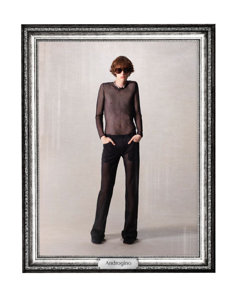 A model in a mesh top and trousers poses in a studio, framed for a fashion editorial. The composition features a neutral backdrop.
