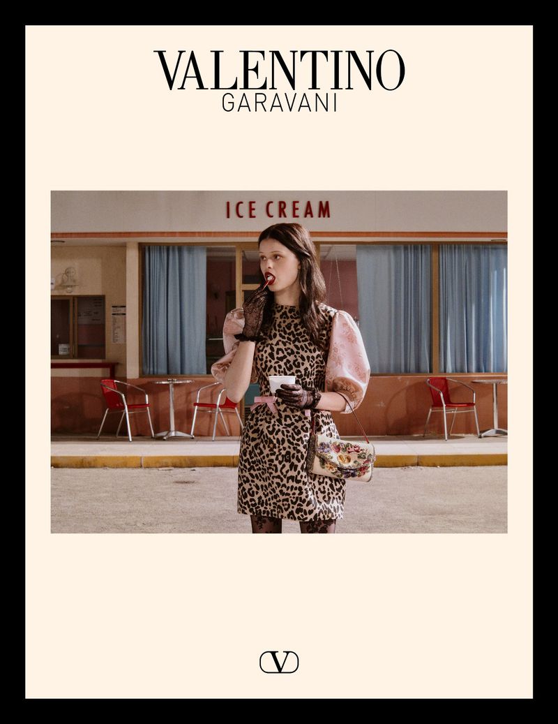 Valentino Garavani advertisement featuring a woman in a leopard print dress eating ice cream outside of an ice cream shop.