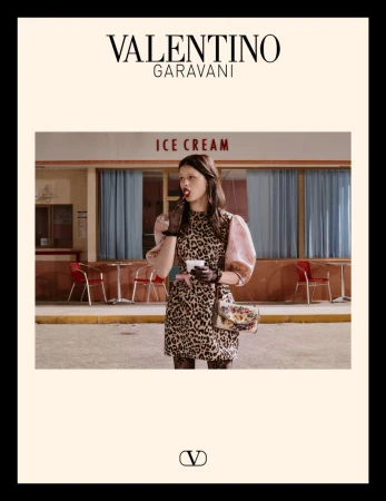 Valentino Garavani advertisement featuring a woman in a leopard print dress eating ice cream outside of an ice cream shop.