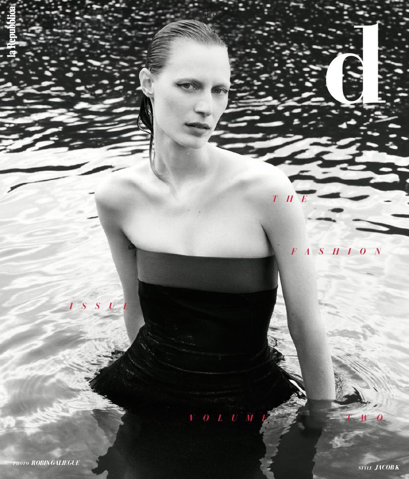 Fashion magazine cover featuring a woman in water wearing a dark dress, promoting the fashion issue, volume two, with water background.