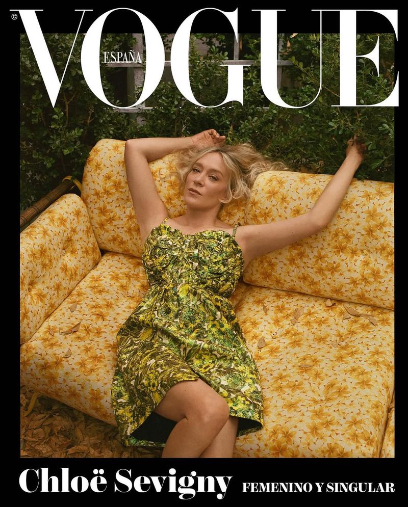 Vogue Espana cover featuring model Chloe Sevigny lying on a floral print couch outdoors surrounded by greenery. Editorial fashion photography.