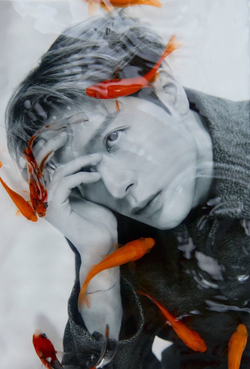 Dreamlike digital composite of an adult with orange goldfish overlay, creating a surreal and captivating portrait with mixed media aesthetic.