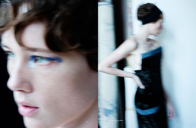 Two young adult women pose in a fashion editorial-style composition with bright blue makeup and a modern black dress indoors.