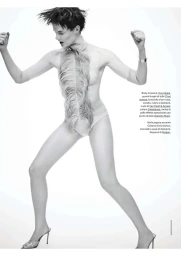 Model Aylah Peterson wearing a feathered bodysuit and heeled sandals against a white seamless background for Elle Italia.