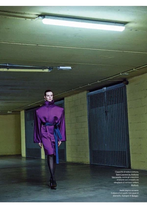 Model Aylah Peterson wearing a structured purple coat walking through a concrete garage interior