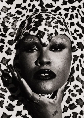 Striking black and white portrait of an African American woman with flawless skin, glossy black lips, and a cheetah print head covering.