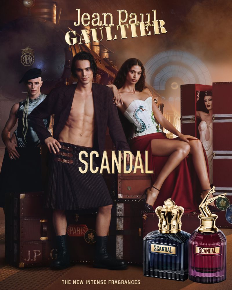 Jean Paul Gaultier's Scandal fragrance ad featuring three models and perfume bottles against a steampunk-inspired backdrop.