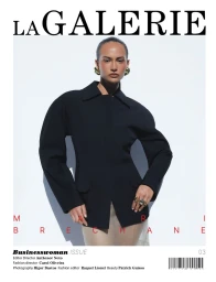 Model wearing a structured black jacket and gold earrings against a plain white background for a magazine cover.