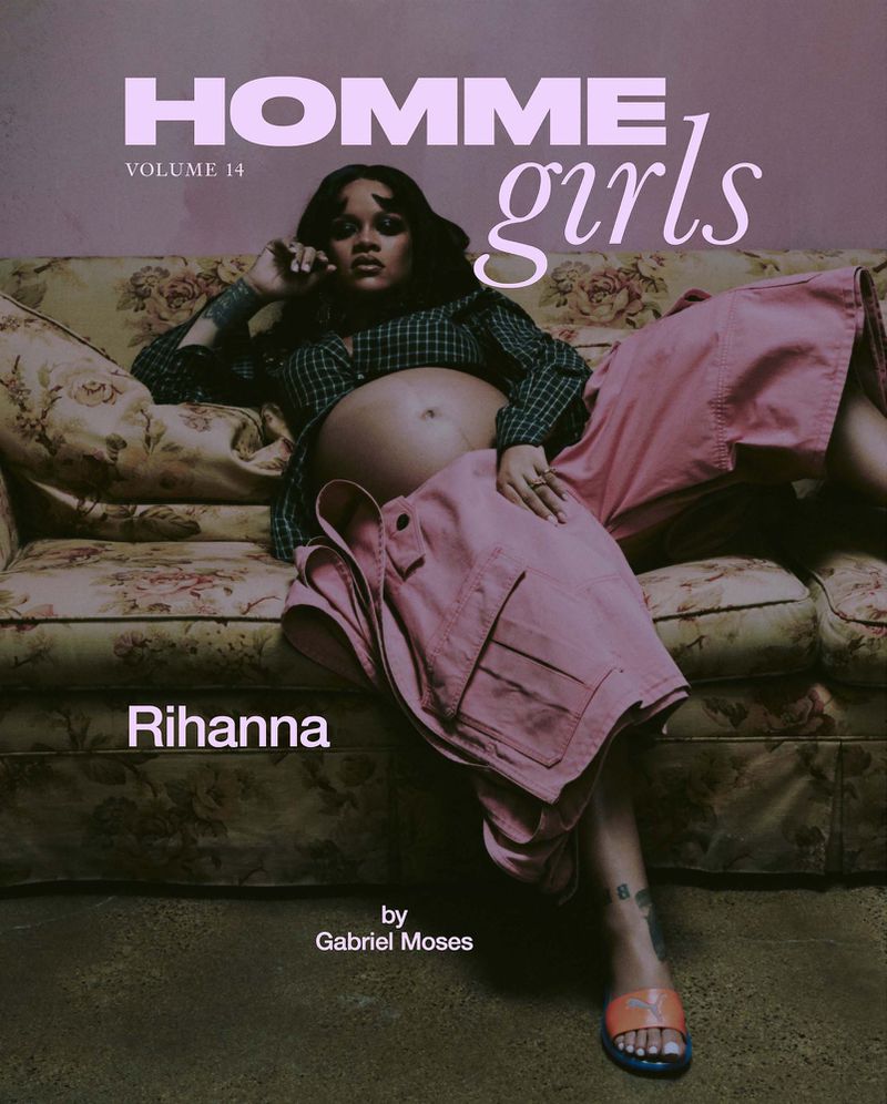 Magazine cover shot of pregnant Rihanna reclining on floral couch in pink pants and green top, gazing at the camera with a serene expression.