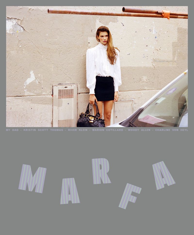 A woman in a white blouse and black miniskirt stands outside with a purse. A grey wall and part of a car are visible in the background.