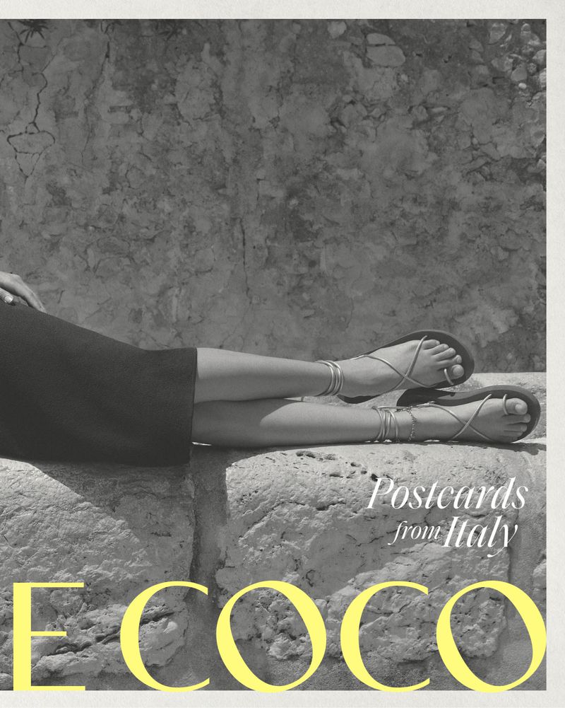 Closeup of a woman's legs resting on a stone structure, showcasing strappy sandals with a natural, textured stone backdrop and bright yellow text.
