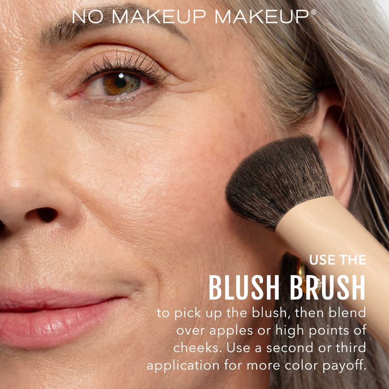 Close-up shot of an adult woman applying blush with a makeup brush.  The model is demonstrating a no-makeup makeup look.