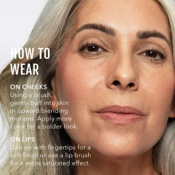 Close-up portrait of an older woman with grey hair showing natural skin texture and minimal makeup