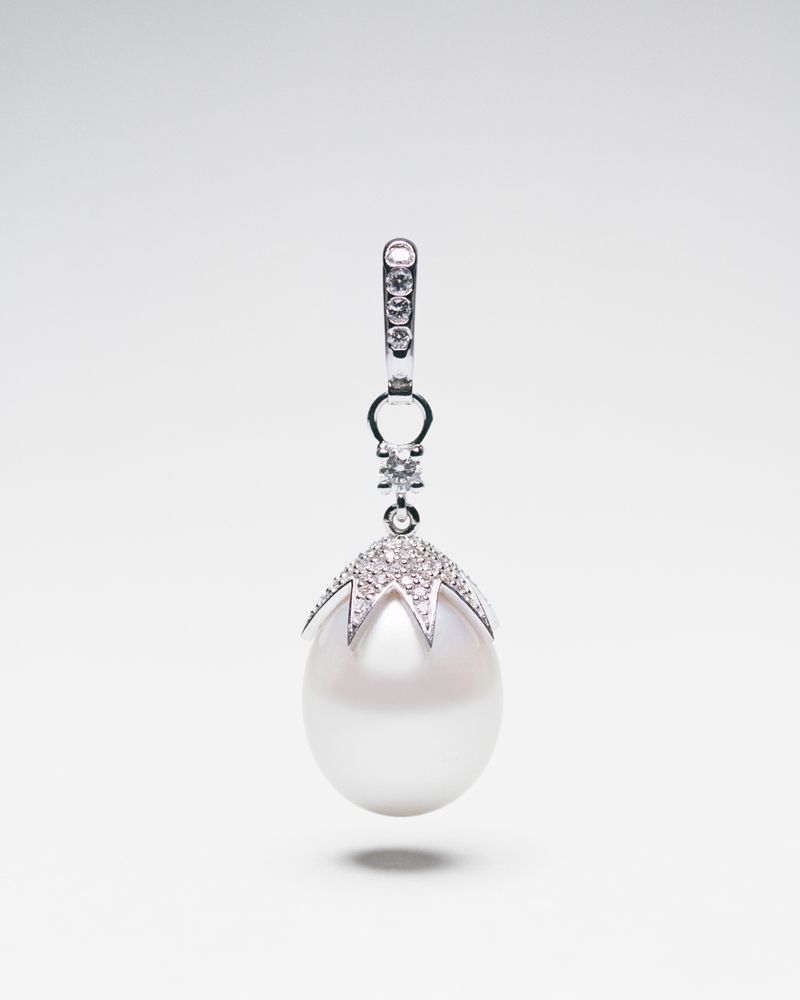 Elegant pearl pendant with diamond accents, showcased against a clean white background, highlighting its luster and intricate design details.