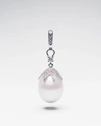 Diamond-encrusted white pearl pendant hanging against a clean white seamless studio background.