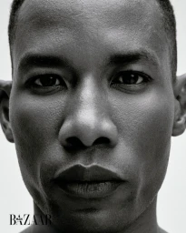 Close-up monochrome portrait of a Black man facing forward against a plain white background for Harper's Bazaar Brazil